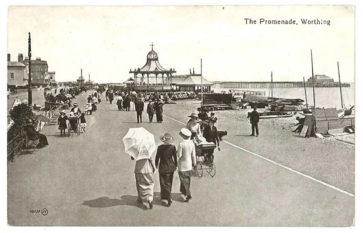 Worthing Pier - people on the promenade near the bandstand with the pier in the distance