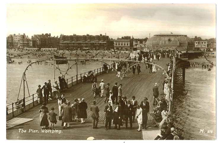 Worthing Pier - view towards the beach along the length of the Pier showing people promenading on the Pier