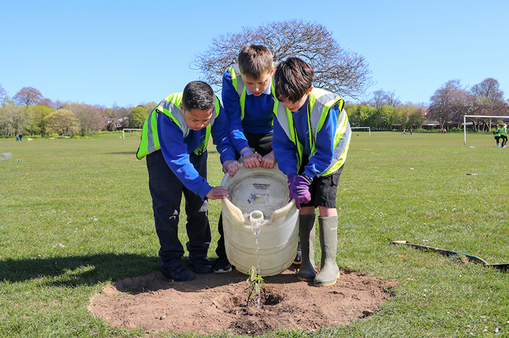 PR21-065 - Sajid, Louie and Leo watering their tree