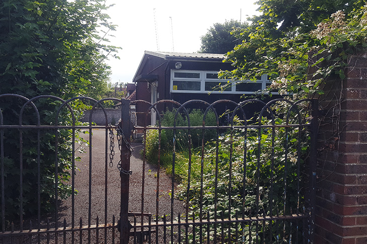 The old RAF Air Cadets site in Victoria Road in Worthing - building viewed through entrance gates (June 2022)