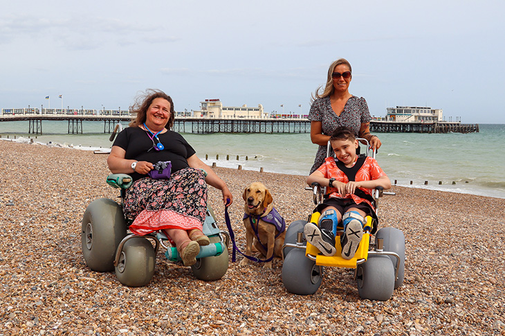 PR23-092 - Carole Harrison pictured with Selina Ragless and her son Harry and the beach wheelchairs on Worthing Beach