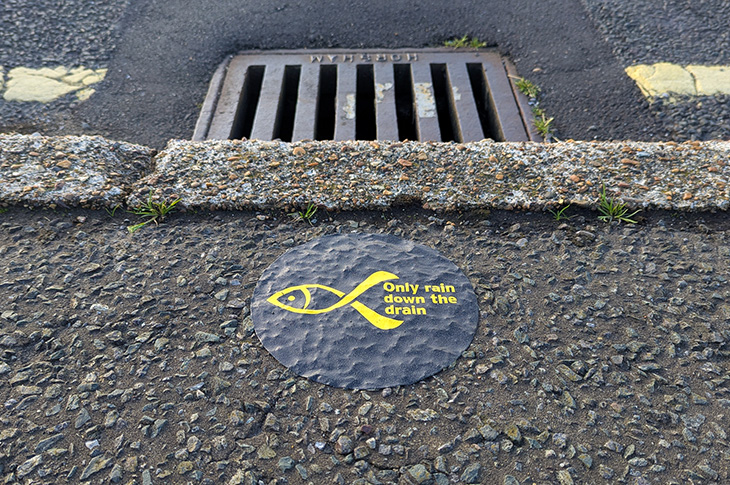 Yellow fish campaign - a sticker by a drain